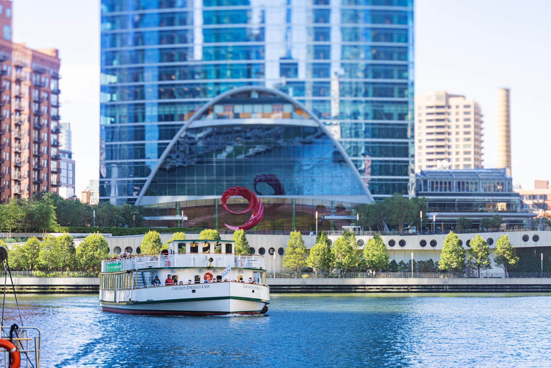 A white boat floats on a body of water in front of a city skyline.
