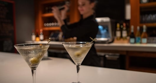 Martinis on Bar with woman making drinks in the background