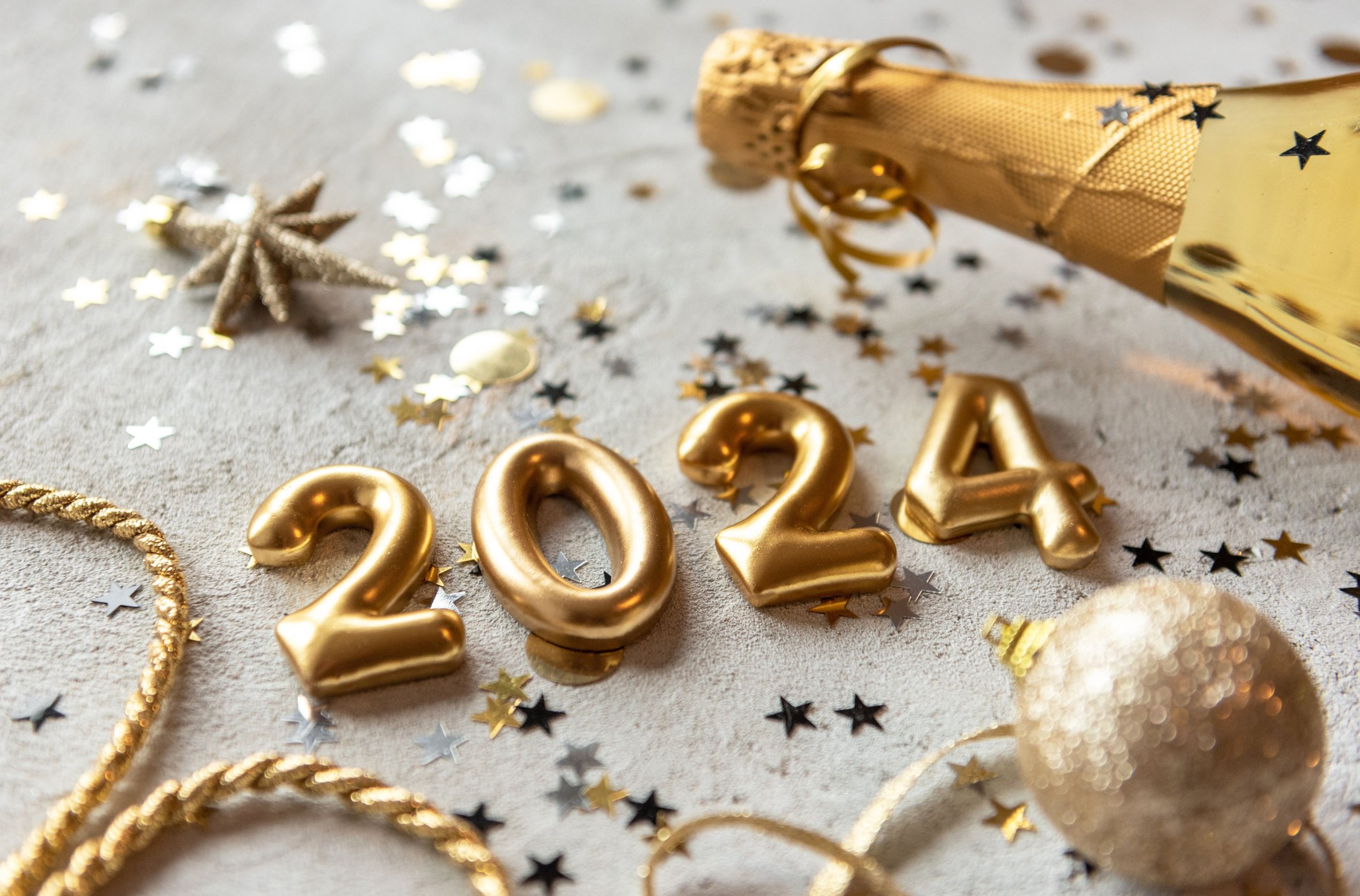 Golden color palette photo with new year 2024 numbers surrounded by confetti and decorations